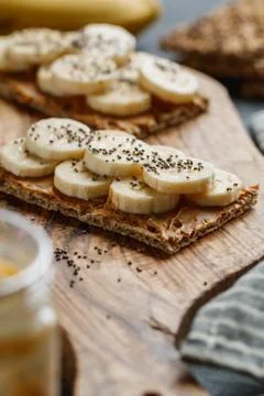 Two multi grain breads with peanut paste, banana slices and chia seeds on a s Stock Photos