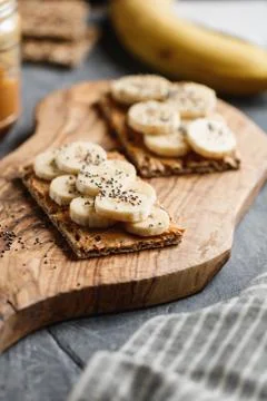 Two multi grain breads with peanut paste, banana slices and chia seeds on a s Stock Photos