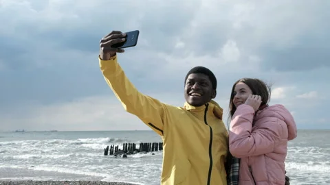 Two multicultural persons of black guy and cute white lady make a photography at Stock Footage 199493013