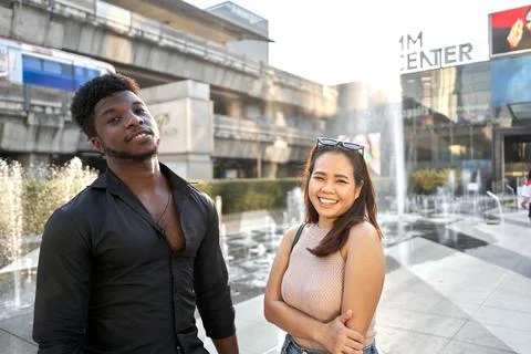 Two multiethnic friends posing friendly in a shopping mall Stock Photos