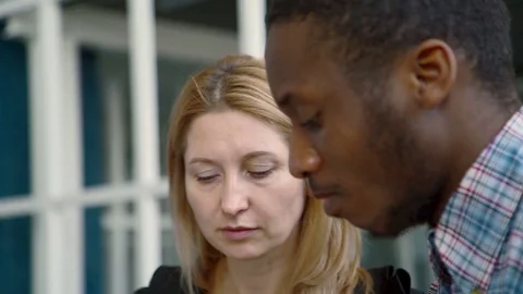 Two multiethnic friends talks about the troubles while watching old photos the Stock Footage 82351427