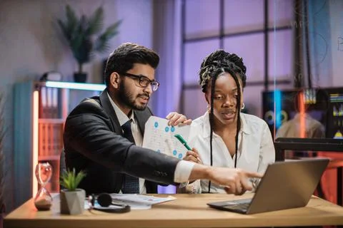 Two multiracial brokers, handsome arab bearded office manager and african Stock Photos