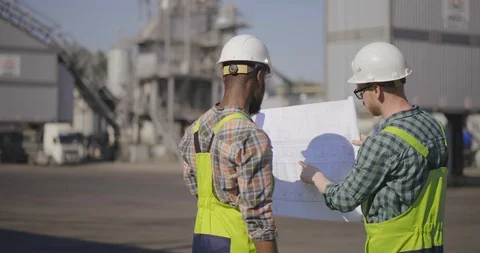 Two multiracial engineers with blueprint Stock Footage 114349287