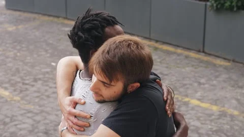 Two multiracial young man friends embrace and enjoying friendship in the street Video stock 218610653
