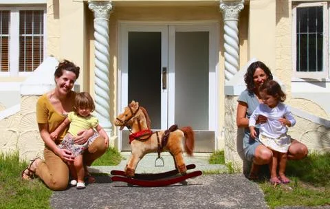 Two Mums with their daughters and a rocking horse Stock Photos