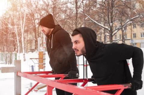 Two muscular men doing workout on parallel bars Foto stock