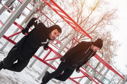 Two muscular men exercising on parallel bars Stock Photos