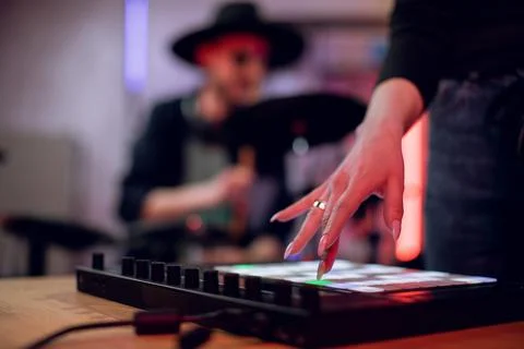 Two musicians creating song using drums and mixing board Stock Photos