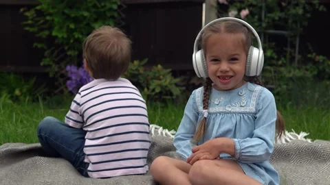Two naughty Siblings dont share. boy ans girl listening to music on headphones Stock Footage 197852325