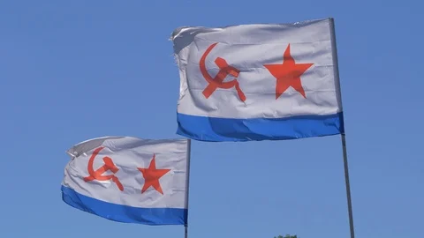 Two naval flags of USSR and Russia waving in the wind on blue sky background Video stock 119279716