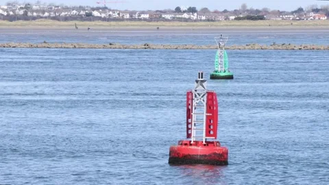 Two navigation channel marker bouys in river estuary Stock Footage