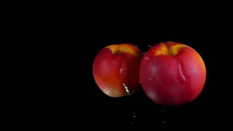 Two nectarines are colliding with each other on black background in slow motion Stock Footage 148870676