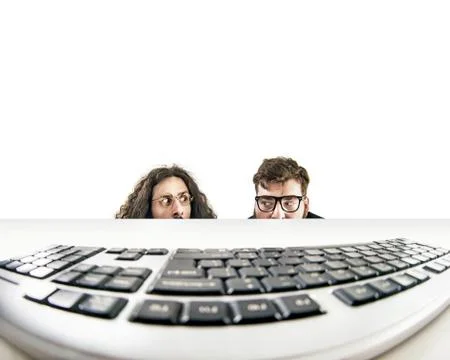 Two nerds staring at a keyboard Stock Photos