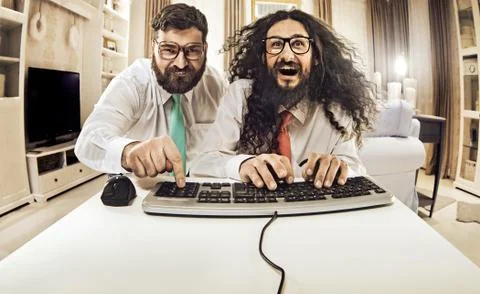 Two nerdy guys working with a computer Stock Photos