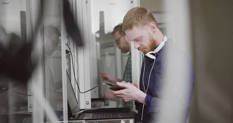 Two network administrators work with server computer and other equipment in Stock Footage 107918028