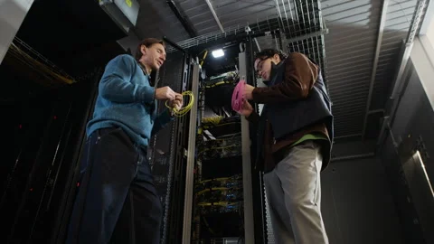 Two Network Engineers Holding Cable Coils and Talking in Data Center Stock Footage 330541934