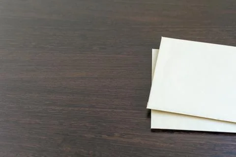 Two new blank sheets of paper on a dark wooden table surface Stock Photos