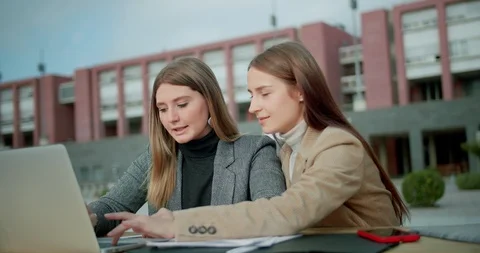 Two nice pensive female students working together on homework research near Stock Footage 120747721