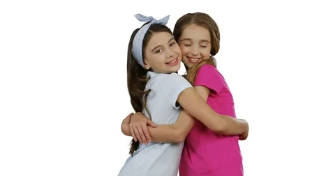 Two nice smiled school friends hugging in front of the camera on the white wall 스톡 동영상 104302268