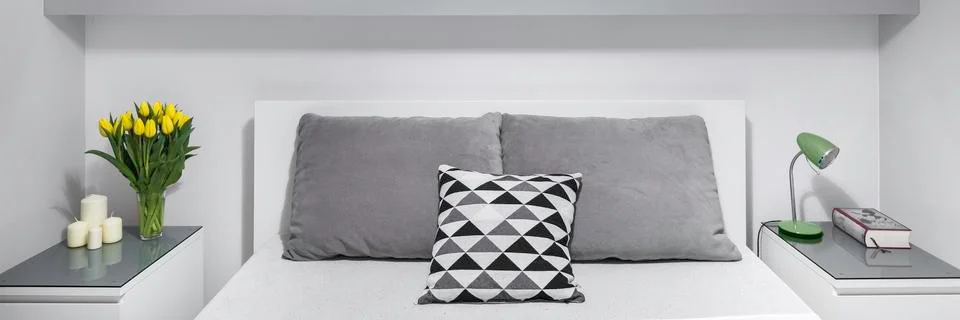 Two nightstands next to bed Stock Photos