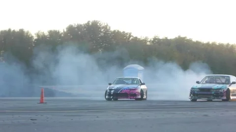 Two Nissan's drift side by side around corner at drifting practice event. Stock Footage 59762057