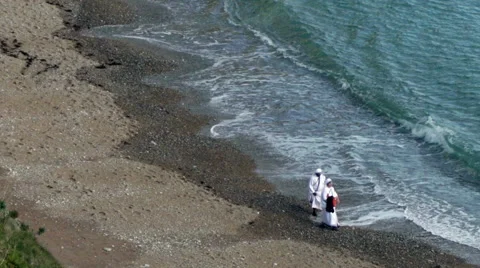 Two nuns walking on the beach Stock Footage 57356302