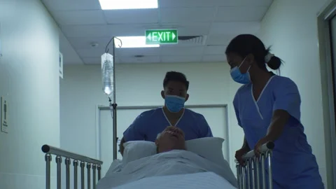 Two nurses in the hospital taking an elderly man to his room Stock Footage 264097524
