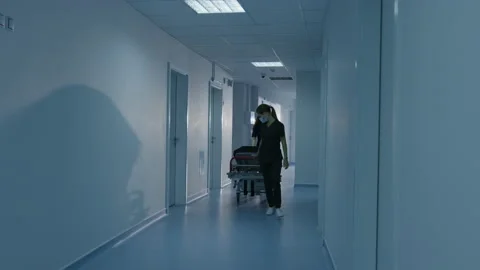 Two nurses roll a gurney along the corridor of the hospital Stock Footage 207999894