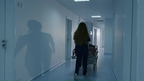 Two nurses roll a gurney down the corridor of the hospital Stock Footage 230246211