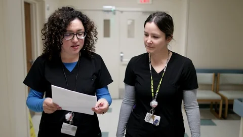 Two Nurses Walking Down a Hallway Stock Footage 127196018