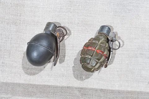 Two objects, one metallic and cylindrical, the other camouflaged and irregu.. Stock Photos