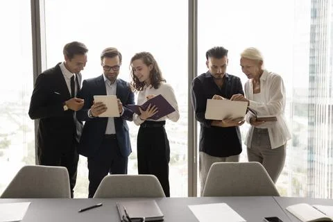 Two office business groups cooperating on tasks, using computer gadgets Stock Photos