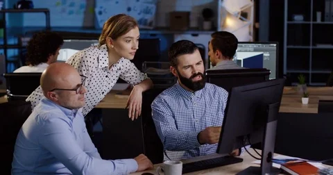 Two office co-workers talking about their new project and demonstrating it to Stock Footage 82447368