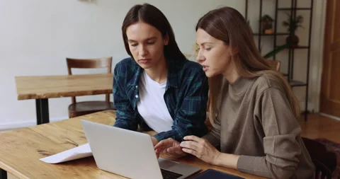 Two office female workers working together in office using laptop Stock Footage 244591719