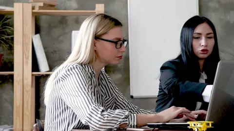 Two office managers are working in the office during working hours. A young 库存影片 131598410