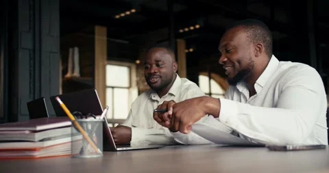 Two office workers with Black skin color in white shirts sit and discuss the Stock Footage 246753079