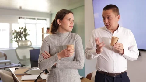 Two office workers drink coffee and chat during a work break Stock Footage 342134937