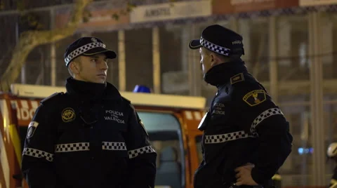 Two officers talking as they wait for Fallas fireworks 4k Stock Footage 61868035