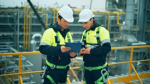 Two oil and gas workers duscussing at refinery industry. Stock Footage