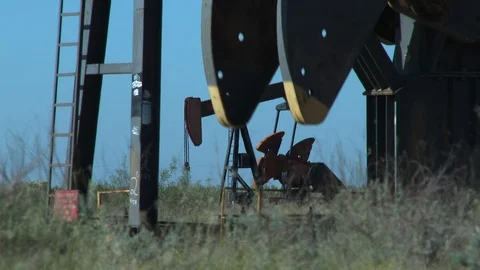 Two oil pump jacks working in tandum on a Texas prairie, 4K. Video stock 94315766