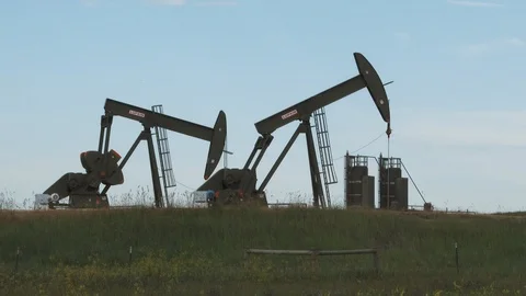 Two Oil Rigs Pumping Well In Field Stock Footage 112944085