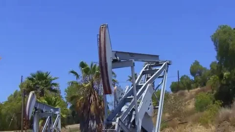 Two oil well jacks derricks pumps extracting petroleum Stock Footage 98578915