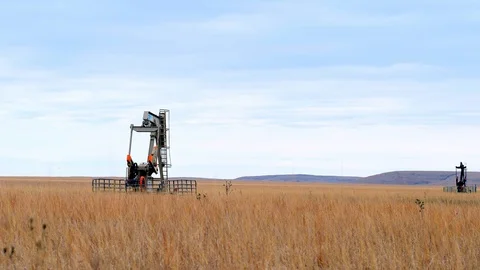 Two Oil Well Pump Jacks pumping crude oil for fossil fuel energy in America Stock Footage 128927843