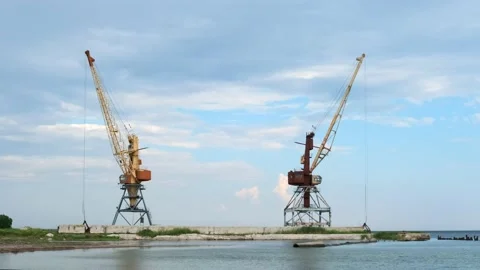 Two old abandoned tower port cranes on a pier on the seashore. Stock Footage 165512409