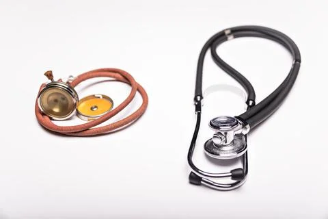 Two old and one modern stethoscope on white background. Stock Photos