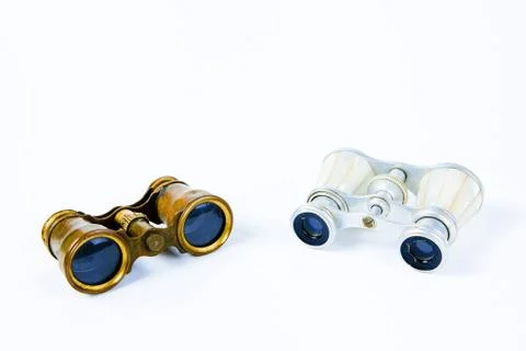 Two old binoculars on white background, brass metal body and silver pearl gri Stock Photos