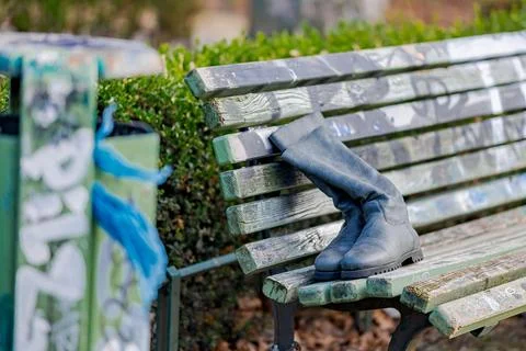 Two old boots on a bench in a park. Foto stock