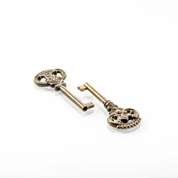 Two old bronze keys with reflection in a white mirror background Stock Photos