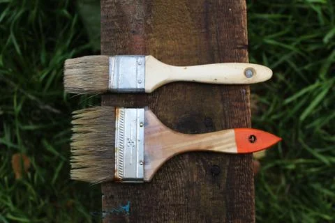 Two old brushes lying on the plank Stock Photos