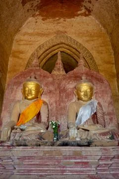 Two old Buddha statues sitting in meditation in Dhammayangyi pagoda in Baga.. Stock Photos